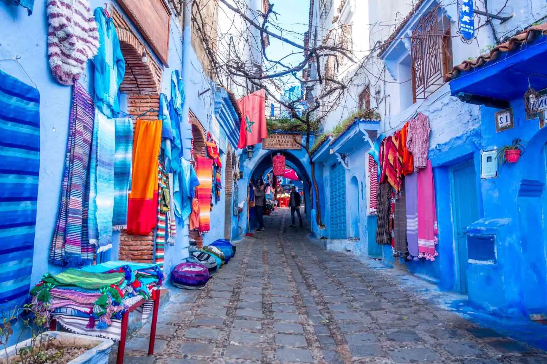 Blue streets of Chefchaouen with colorful textiles